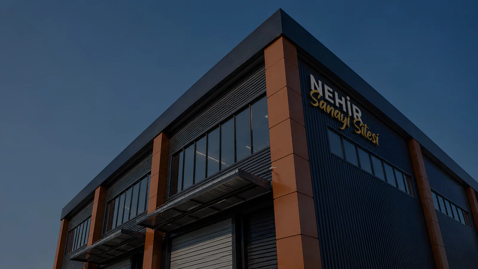 Nehir Sanayi Sitesi'nin lacivert ve bronz cepheli iş yeri binası
